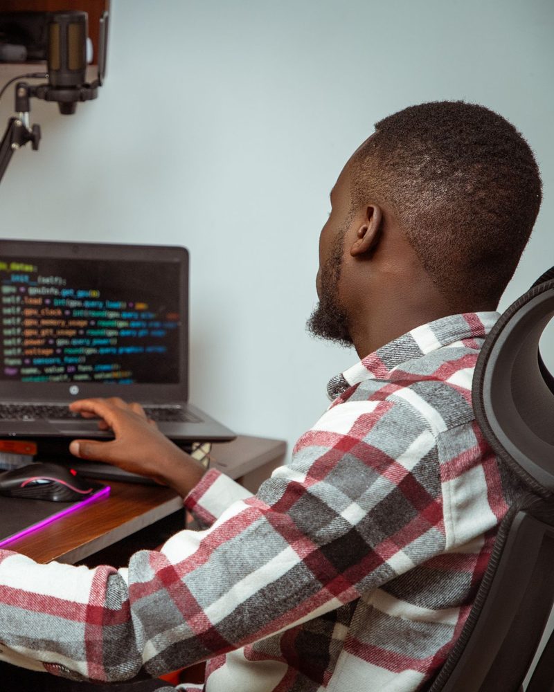 Un ingénieur au travail sur son poste de développement, deux écrans affichant du code